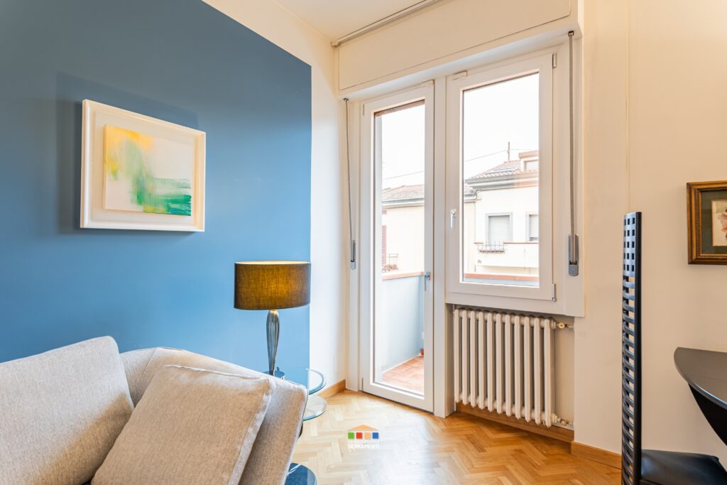 Infisso a bandiera in PVC bicolore con doppio vetro: lato interno bianco effetto legno, lato esterno effetto legno rovere dorato nel rispetto delle norme condominiali