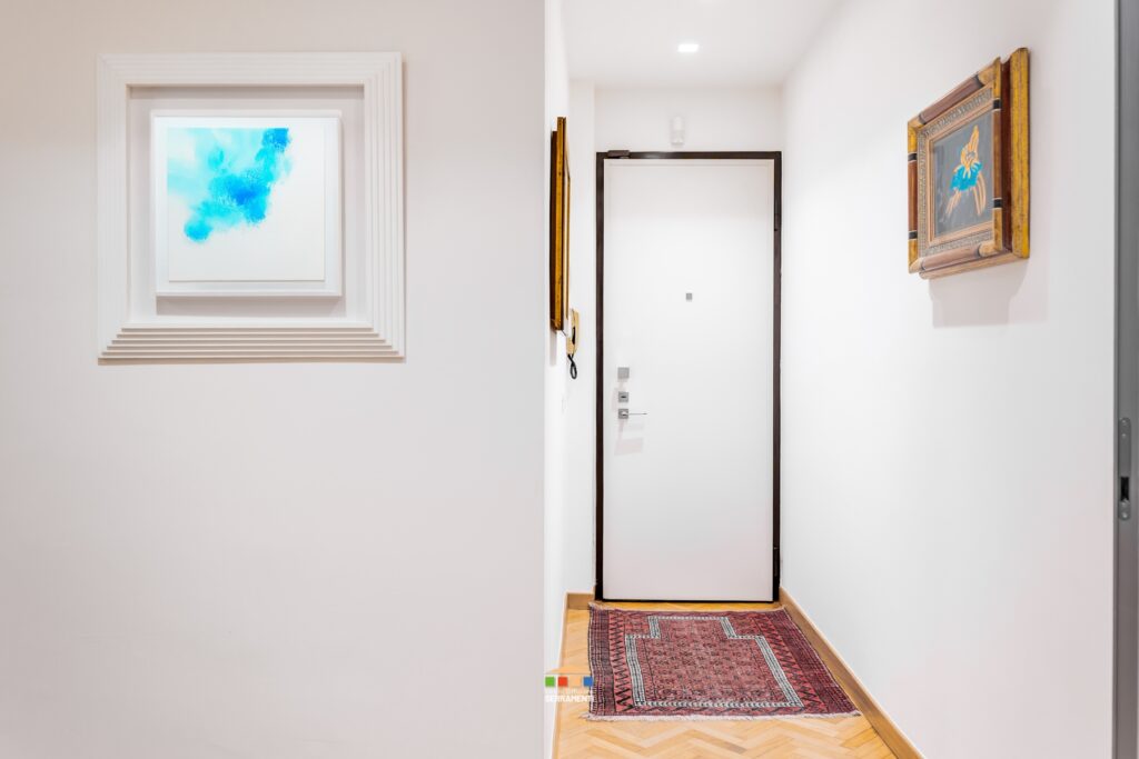 Rivestimento di un blindato esistente. Nessun intervento invasivo: il blindato esistente è stato solo sistemato per essere più coerente con lo stile della casa: abbiamo sostituito il pannello originale in questo bianco liscio e la maniglieria come il resto degli infissi