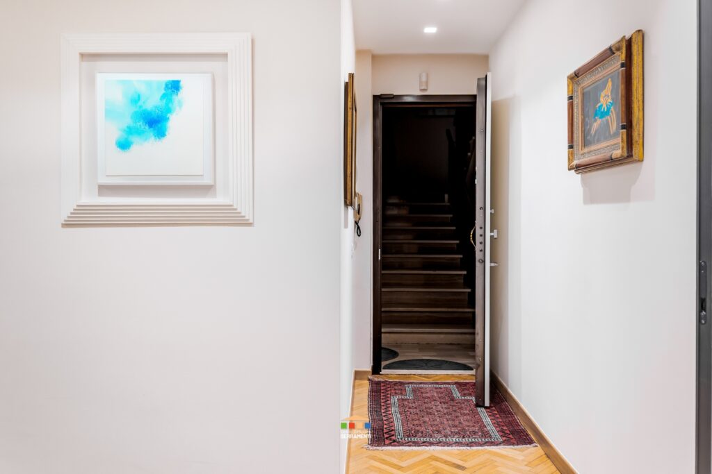 Rivestimento di un blindato esistente. Nessun intervento invasivo: il blindato esistente è stato solo sistemato per essere più coerente con lo stile della casa: abbiamo sostituito il pannello originale in questo bianco liscio e la maniglieria come il resto degli infissi